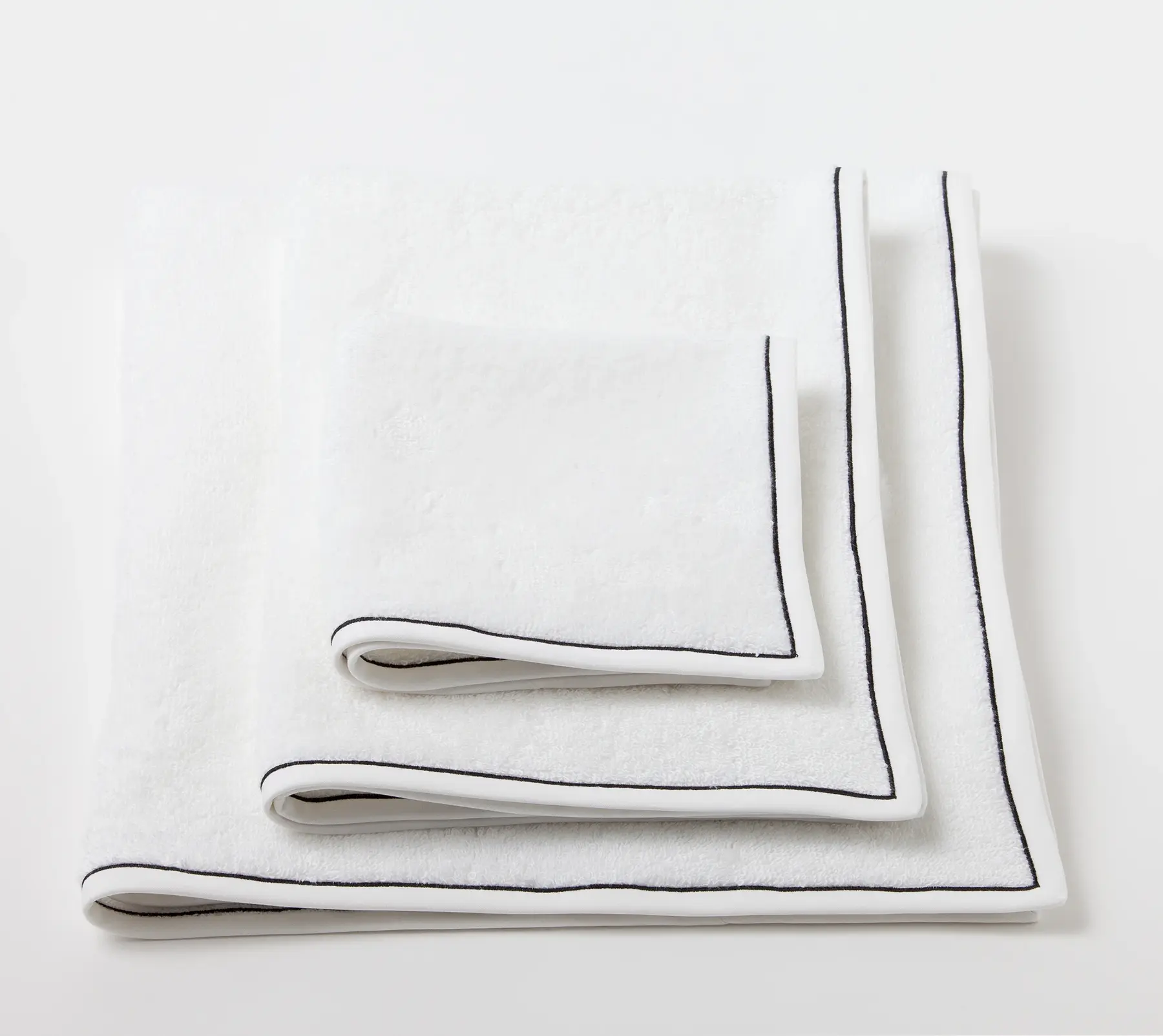White bath linen with black trim, folded