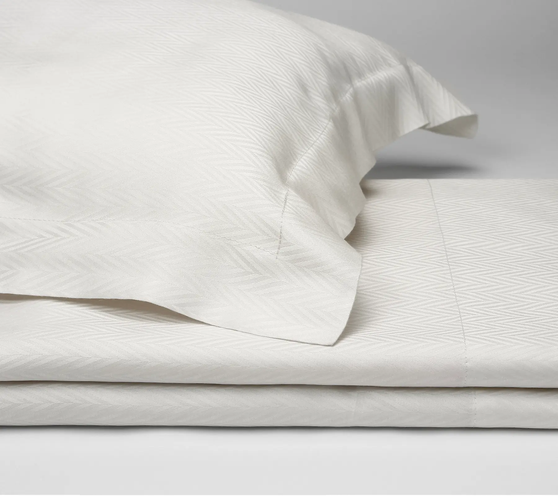 Detail of white Beltrami bed linen with a zigzag stripe pattern.