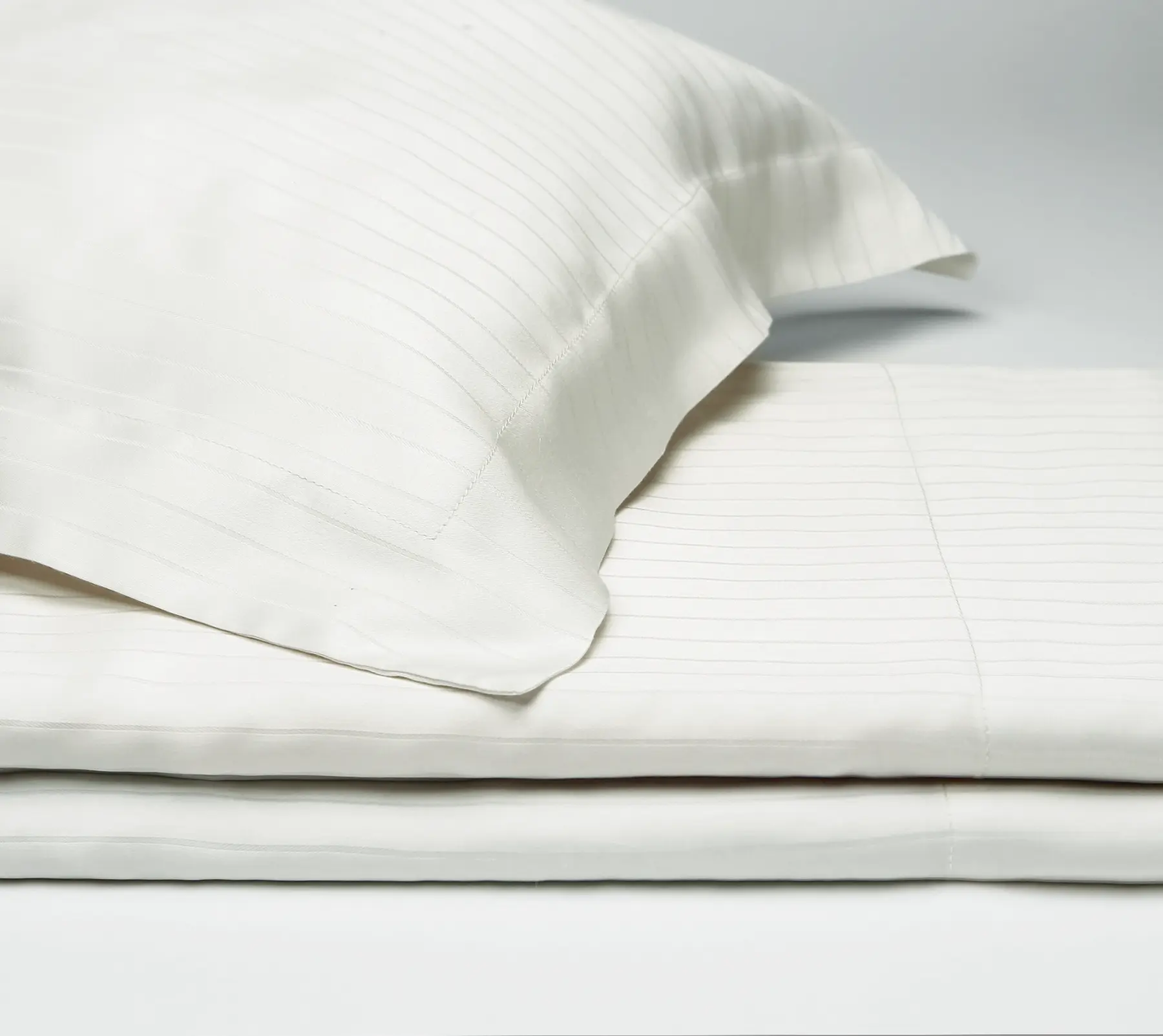 Detail of white Beltrami bed linen with a simple striped pattern.