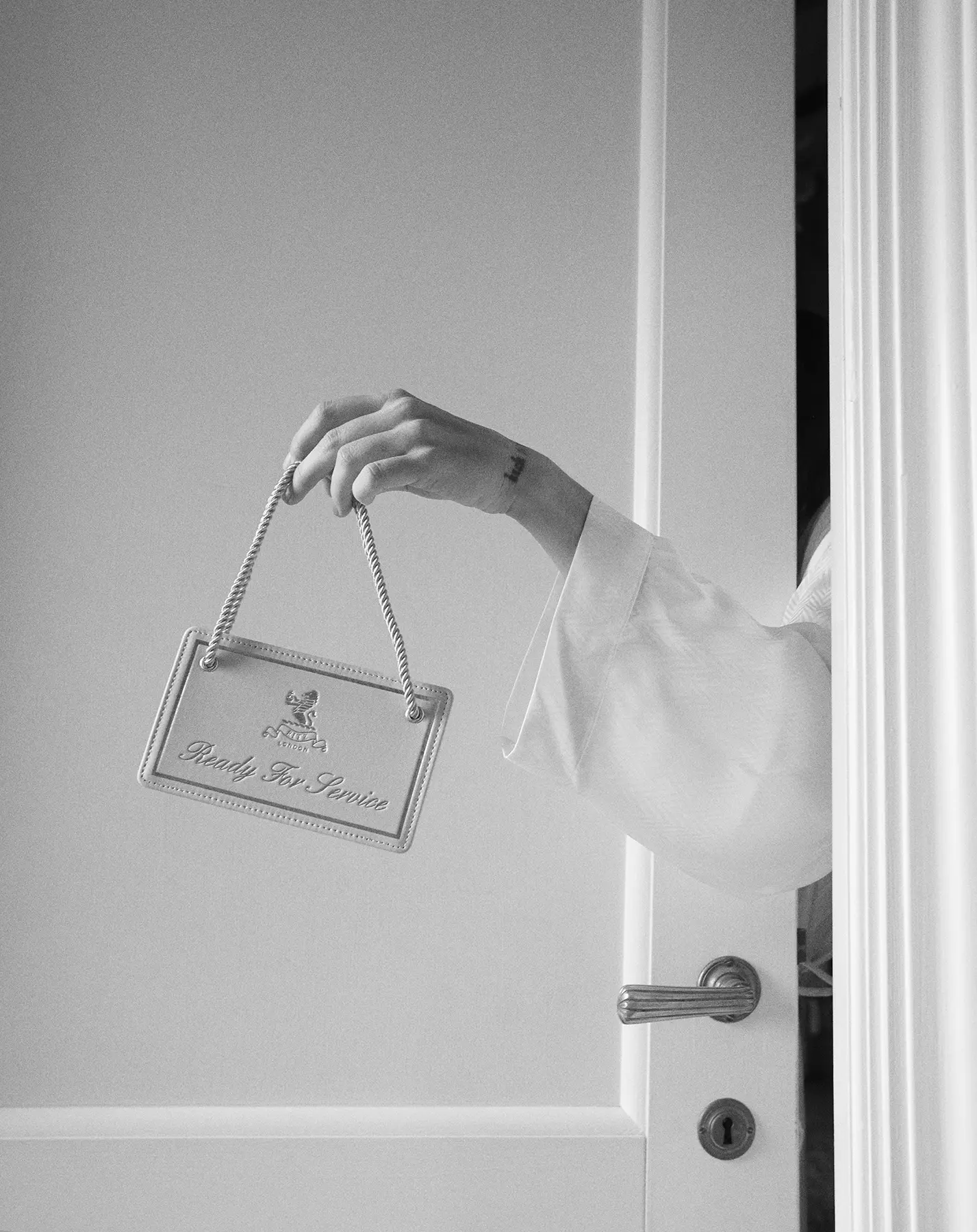 Hand of a woman wearing white Beltrami lingerie holding a hotel room tag