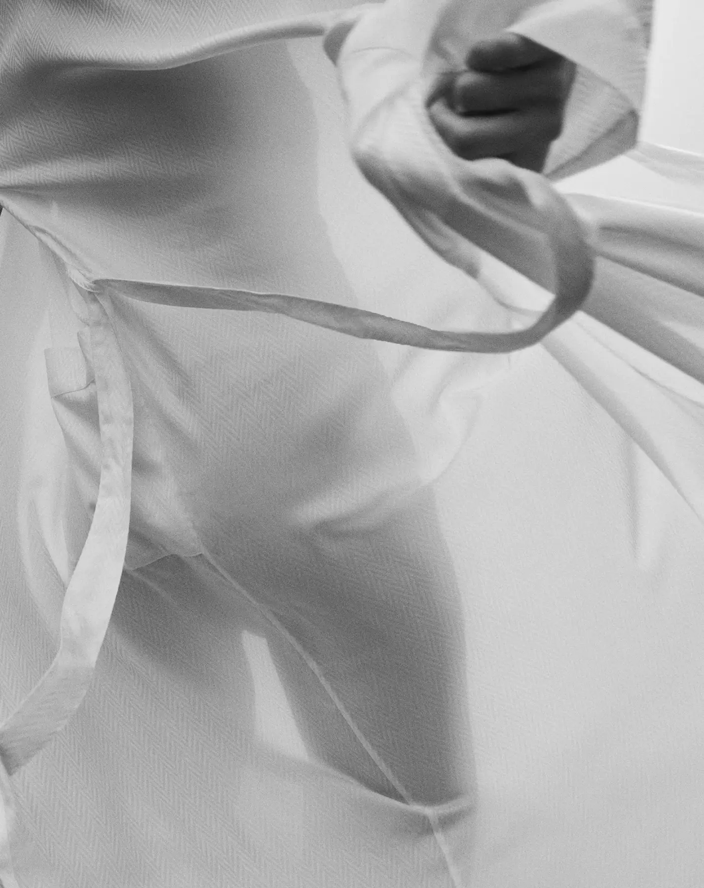 Fingers gripping a fold of cloth to judge its hand